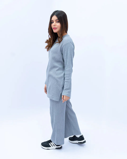 Woman wearing a gray tracksuit on a white background