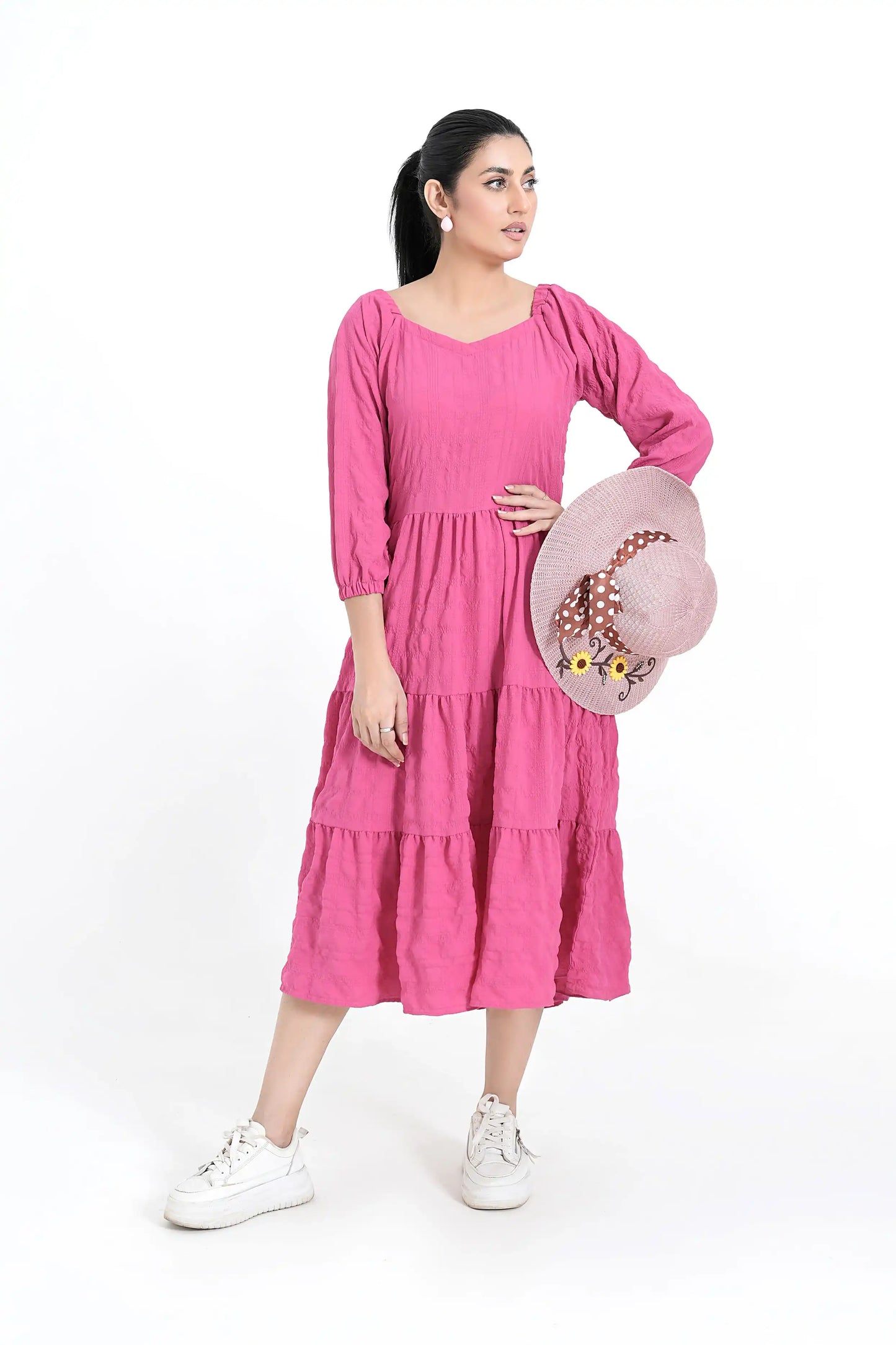 Woman wearing a pink dress holding a hat