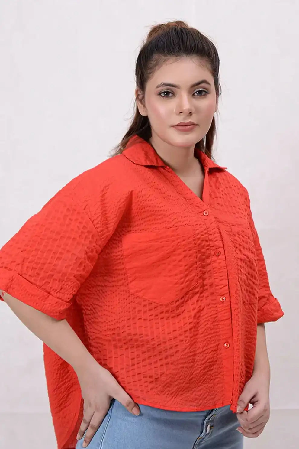 Woman wearing a red textured shirt against a white background