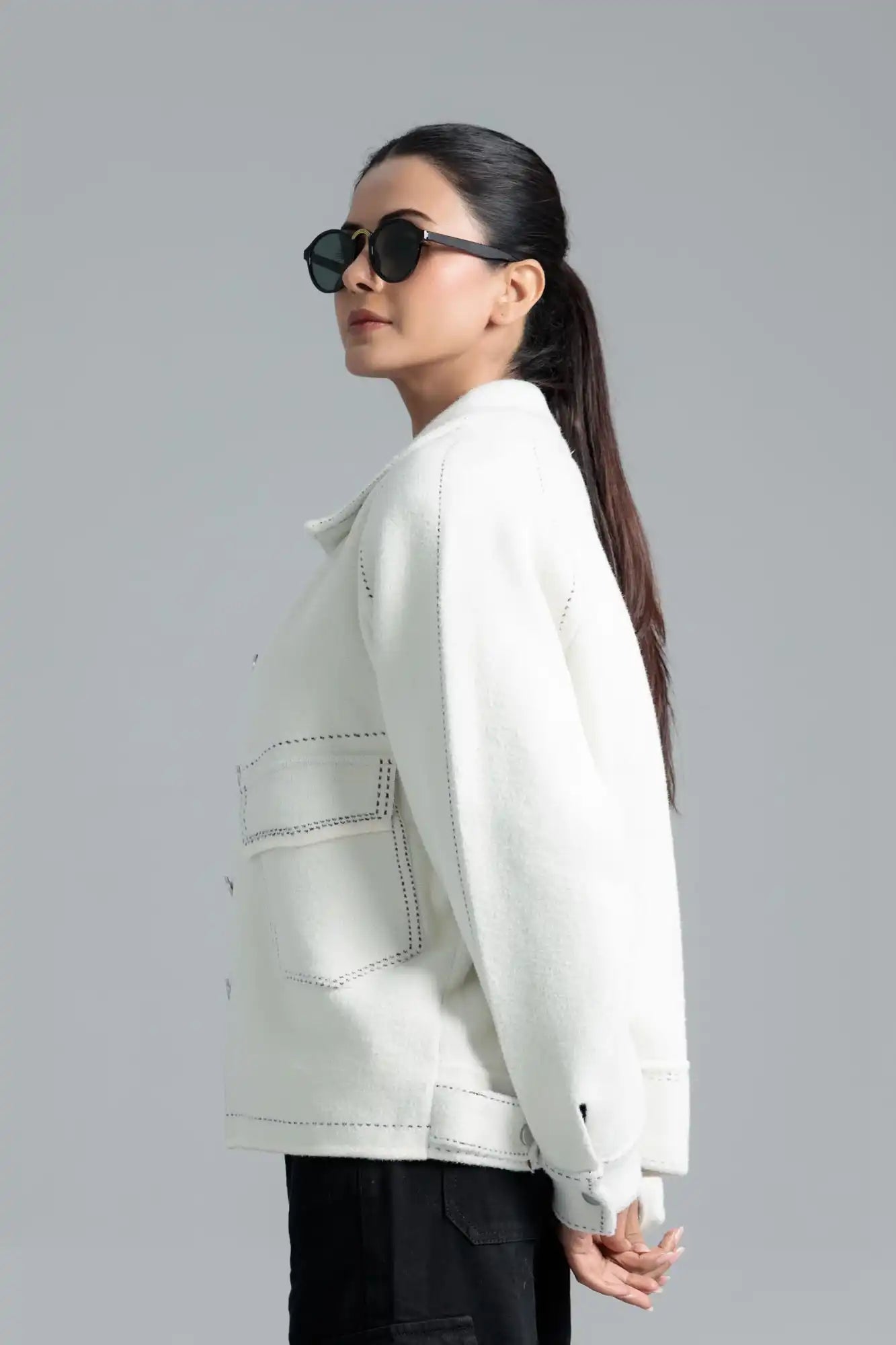 A woman wearing a white jacket and sunglasses 