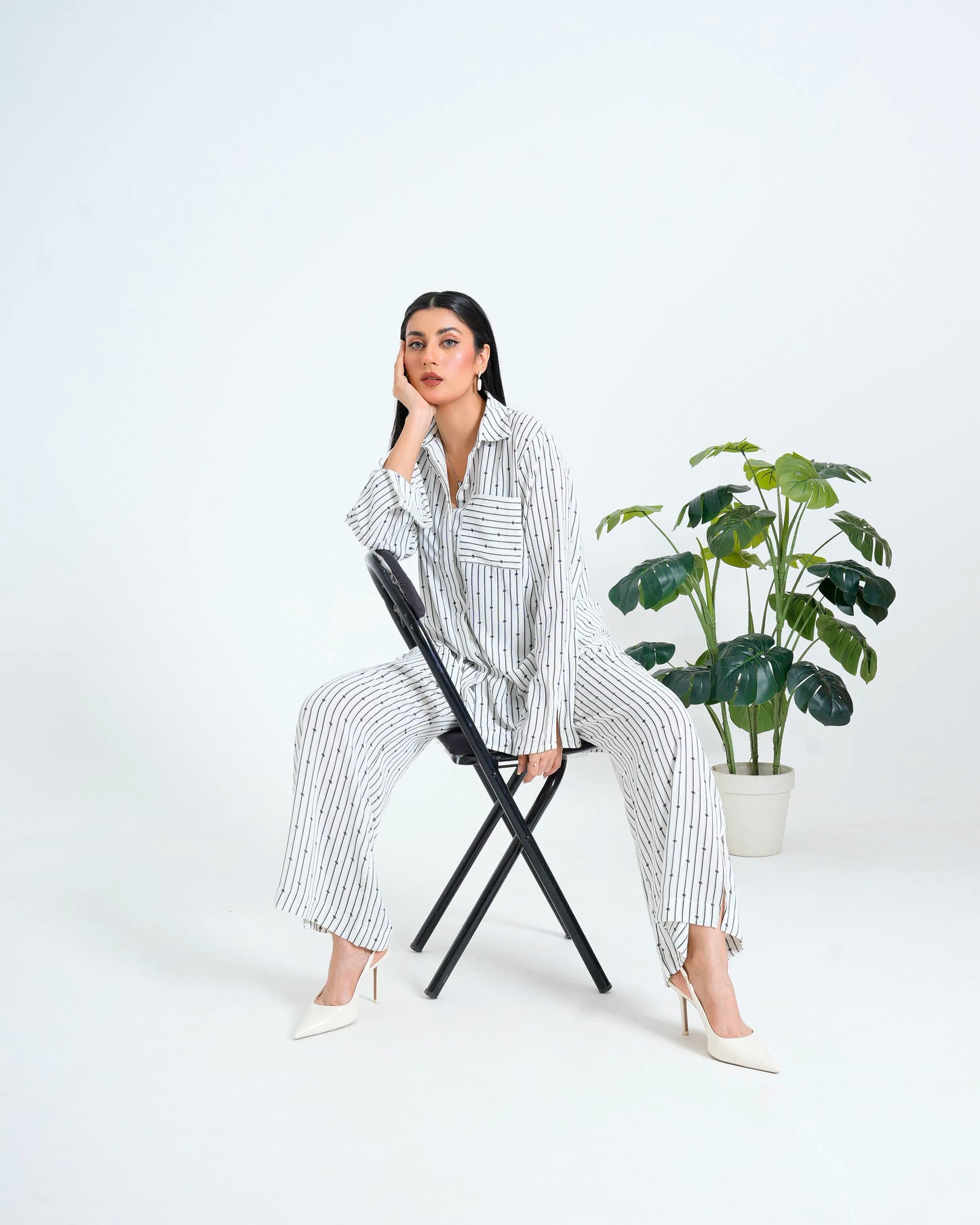 Women wearing a white co-ord set, sitting on a chair