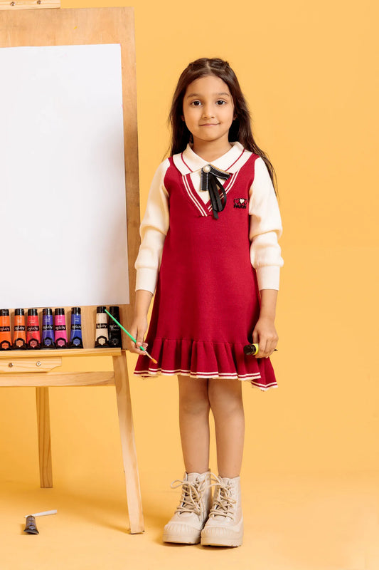 Young girl in a red dress with a white shirt and beige shoes standing next to an easel
