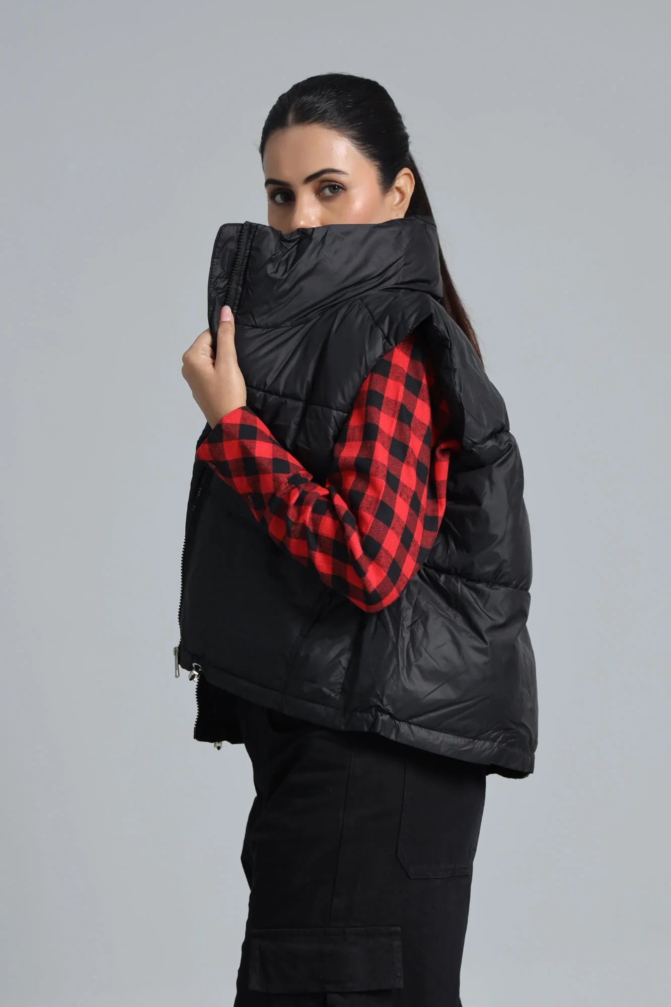 Black puffer vest over a red and black checkered shirt